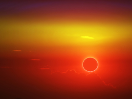 total sun eclipse over cloud sunset orange sky