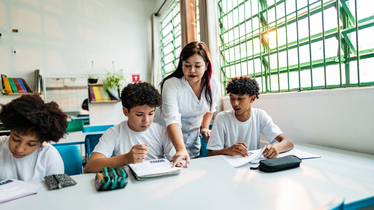 Mature teacher assisting students during class at school