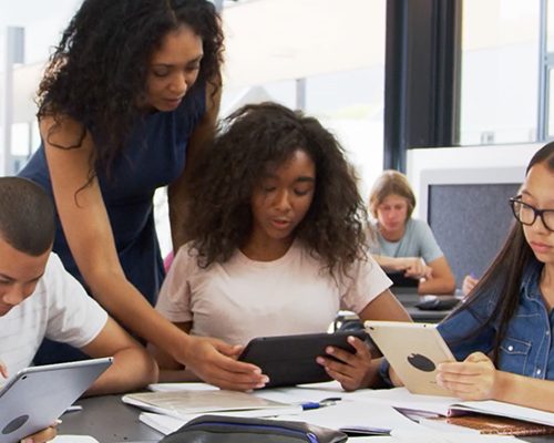 Teacher with students working on tablets
